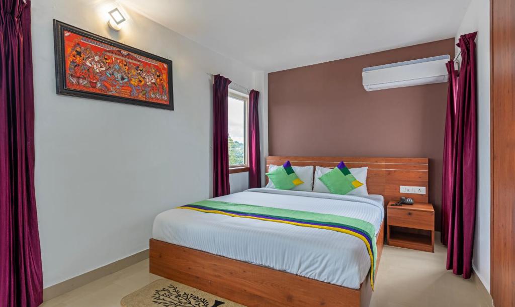 Schlafzimmer mit einem Bett und einem Fenster in der Unterkunft Treebo Trend JP Residency in Thiruvananthapuram