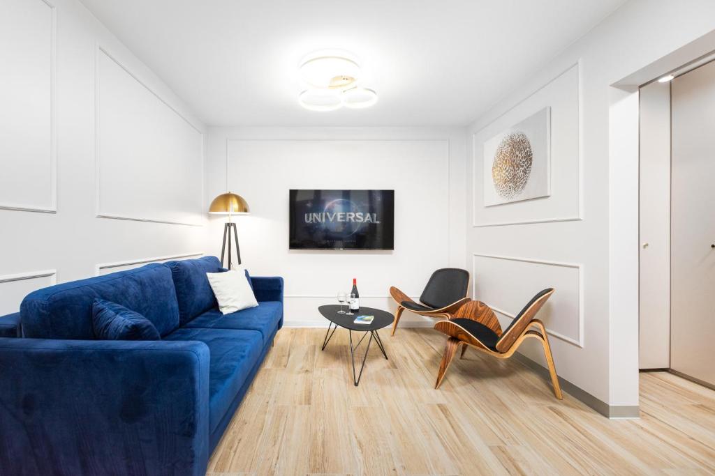 a living room with a blue couch and chairs at Apartament Grzybowska Premium by Your Freedom in Warsaw