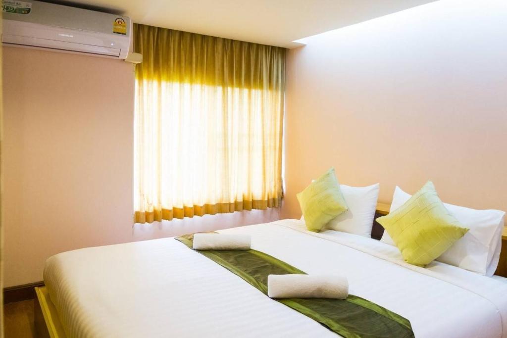 Duas camas brancas num quarto com uma janela em NOP PLACE BANGNA em Ban Bang Phrao