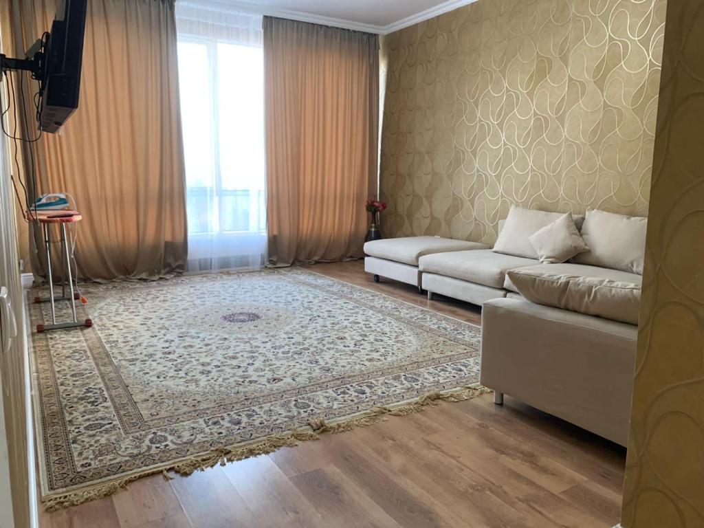 a living room with a couch and a rug at Квартира in Almaty