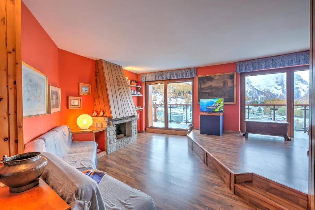 een woonkamer met oranje muren en een open haard bij Terrazza Dei Principi Few Steps From Ski - Happy Rentals in Sestriere