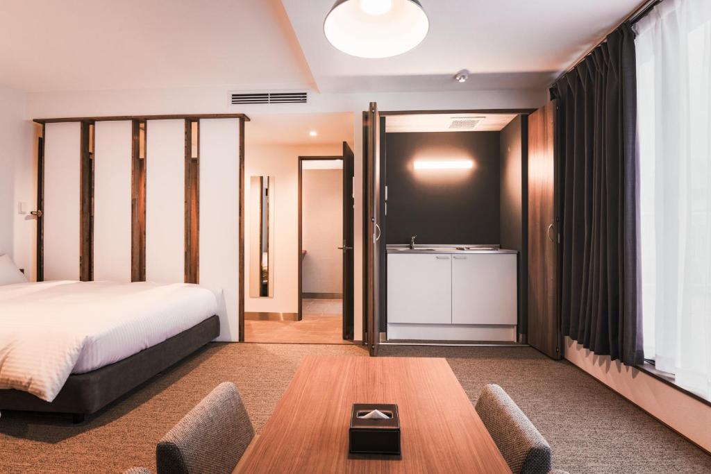a hotel room with a bed and a sink at WAYFARER Shinsaibashi in Osaka