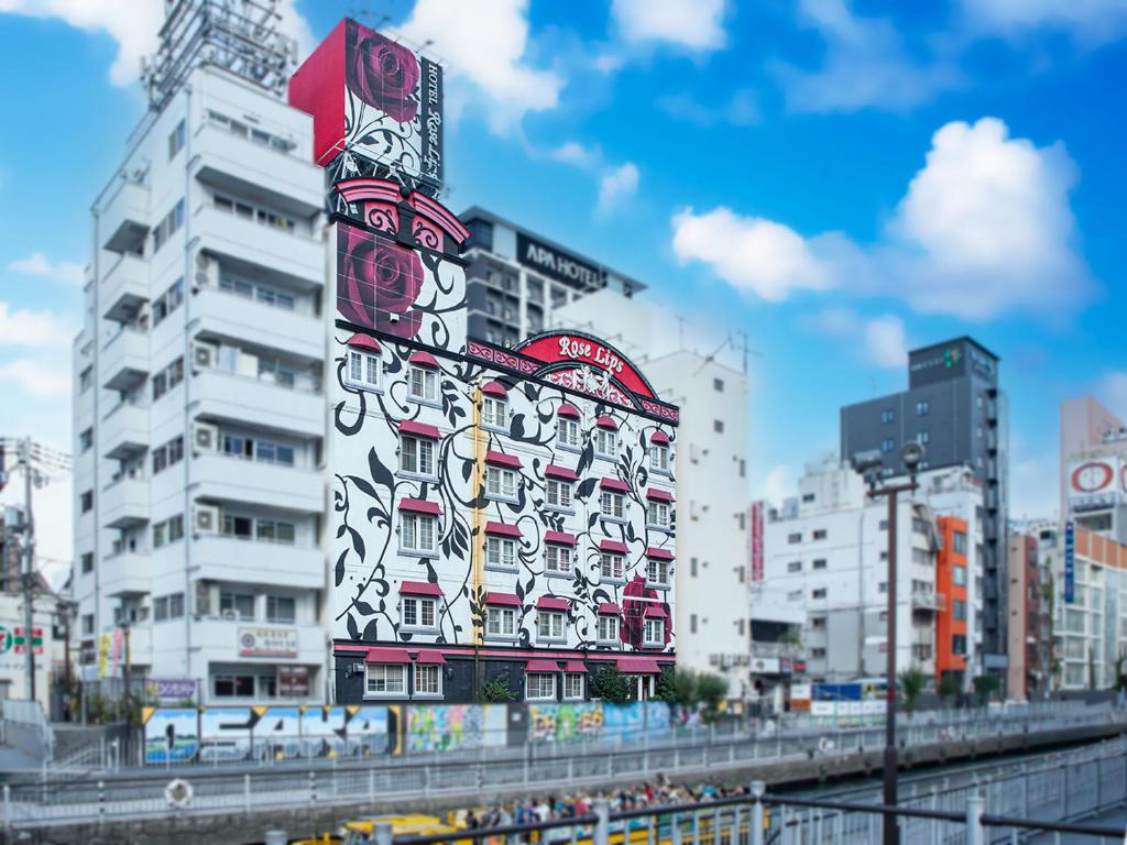 un grand bâtiment avec un panneau sur son côté dans l'établissement Rose Lips Shinsaibashi ローズリップス心斎橋, à Osaka