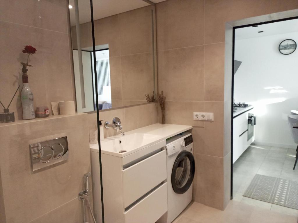 a bathroom with a sink and a washing machine at New and comfortable apartments in Uzhhorod
