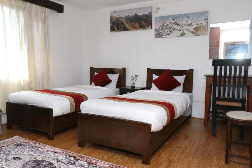 2 bedden in een kamer met witte en rode kussens bij Himalaya Inn in Kathmandu