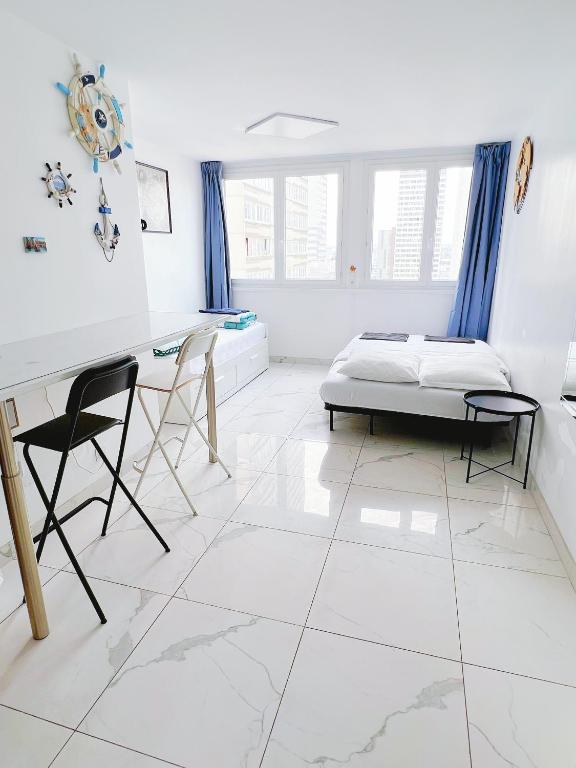 Apartment near subway and supermarket في باريس: غرفة بيضاء مع سرير ومكتب وكراسي
