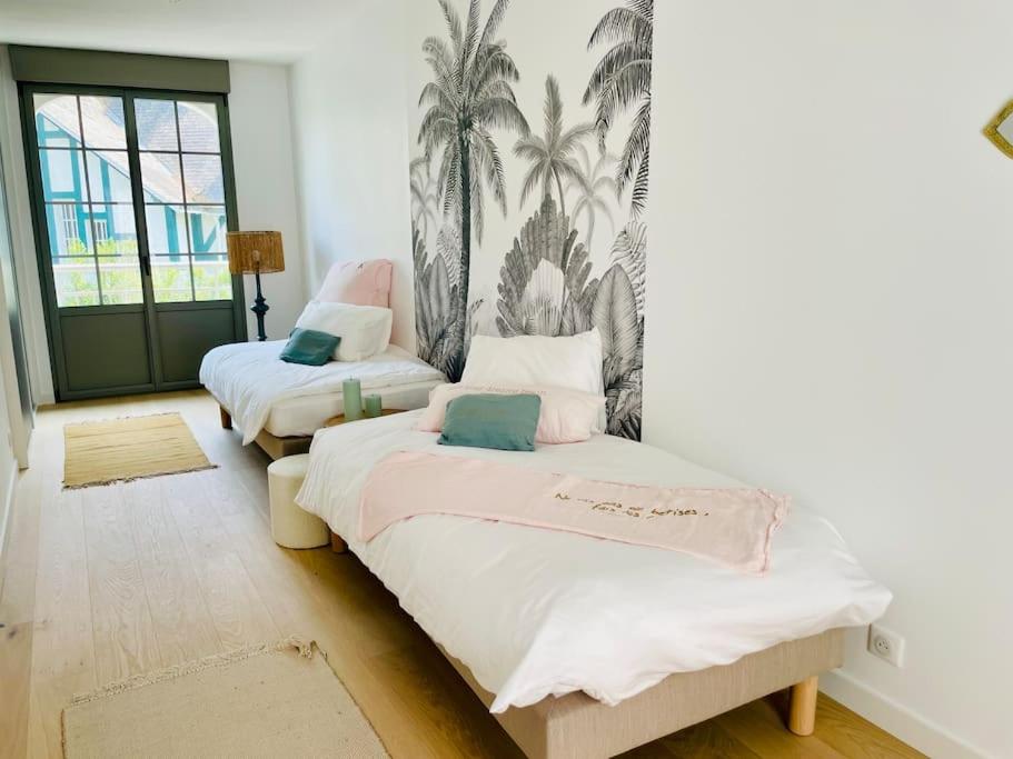 2 camas en una habitación con palmeras en la pared en Villa Mary-Alex La Baule, en La Baule