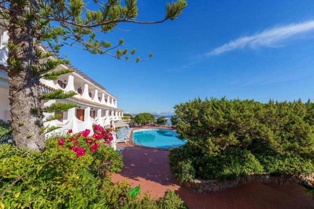 una vista aérea de un complejo con piscina y flores en Hotel Punta Est, en Baja Sardinia