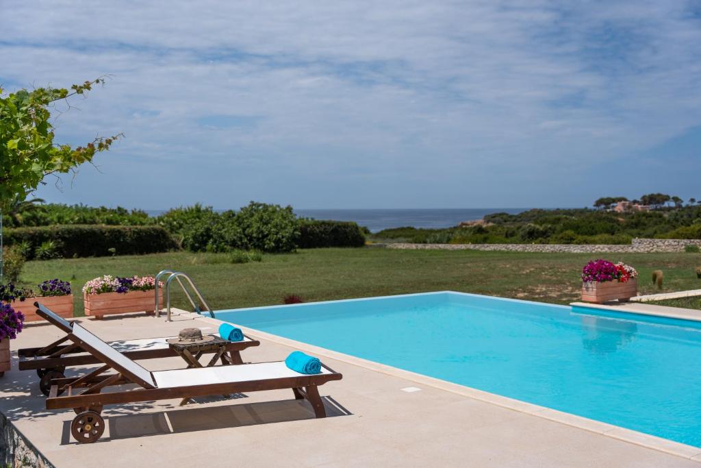 a swimming pool with a table and chairs next to it at Aleli Villas with Tennis Court in Minia