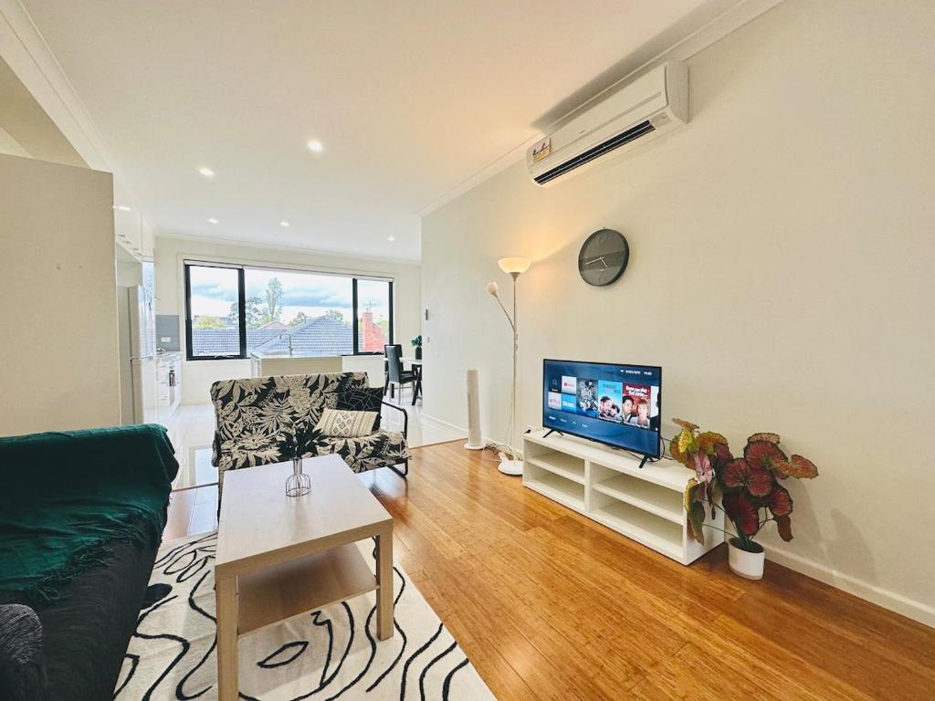 a living room with a couch and a tv at Mt Waverley Spacious 2br2ba Parking Wifi Balcony in Mount Waverley