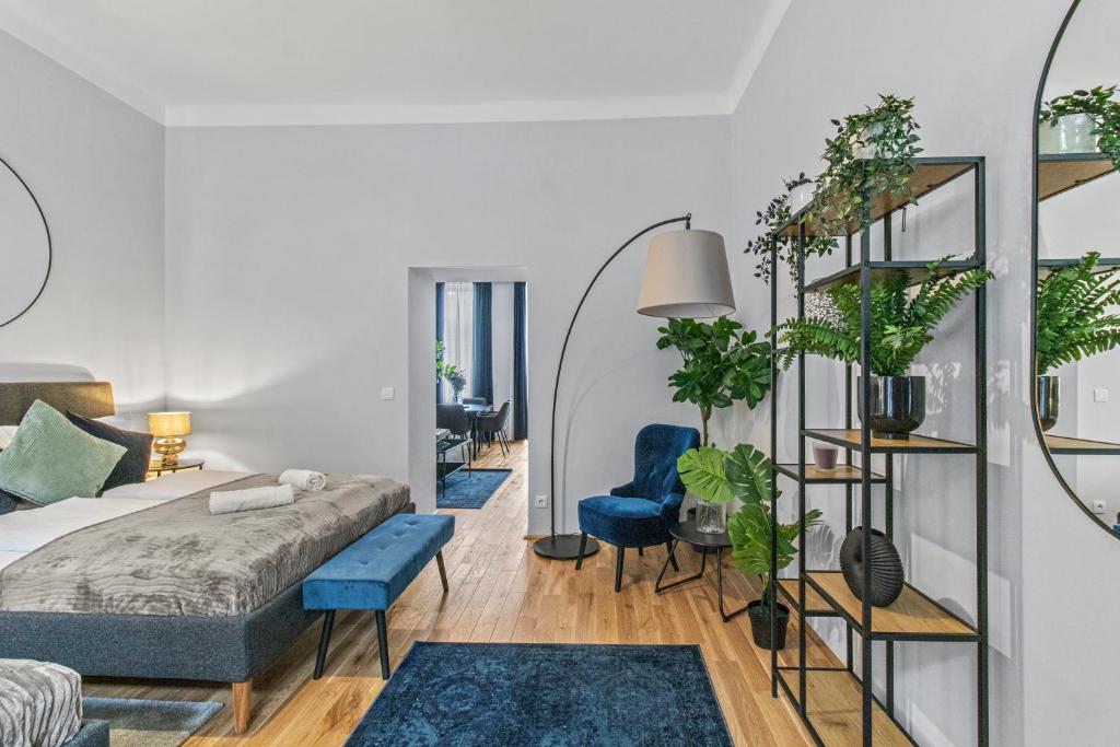 - une chambre avec un lit, des fauteuils bleus et des plantes dans l'établissement Balcony Apartment, 4 min to U3 Zipperer Straße, à Vienne