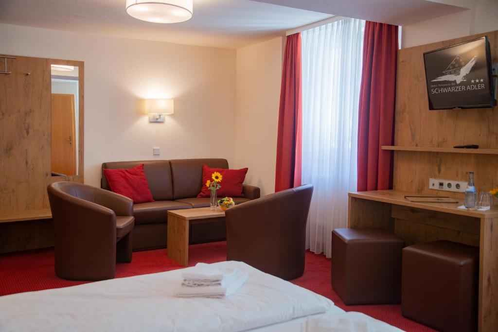 a hotel room with a bed and a couch at Hotel Restaurant Schwarzer Adler in Bad Saulgau