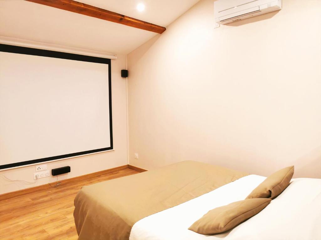 a bedroom with a large screen in the wall at Appart Hotel Cinéma Perpignan in Perpignan