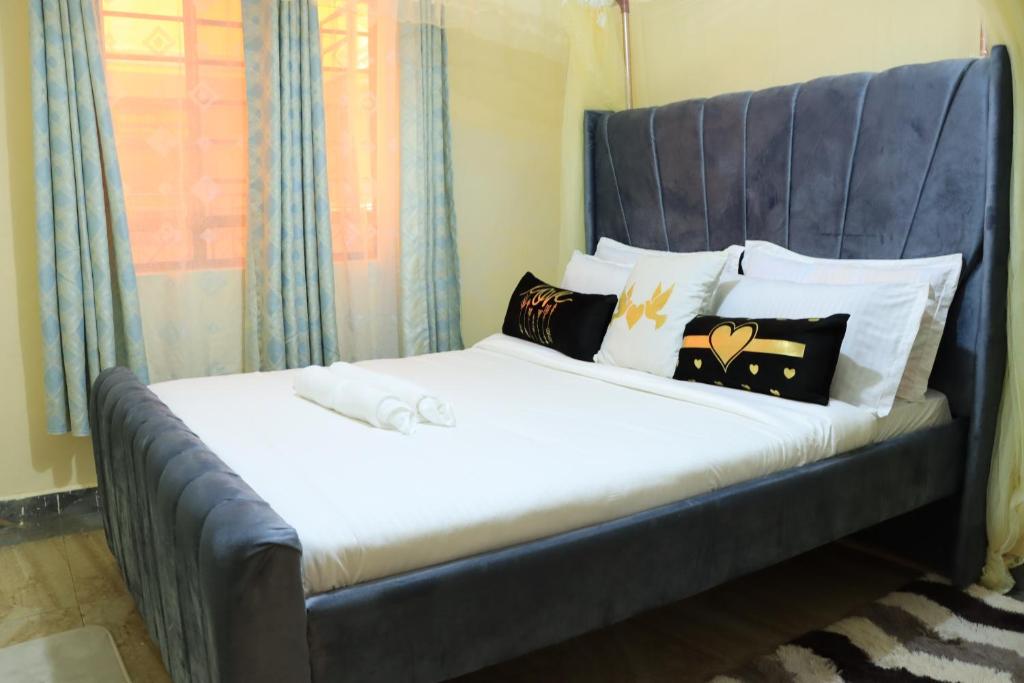 a bed with a blue headboard in a room at GP homes in Nyeri