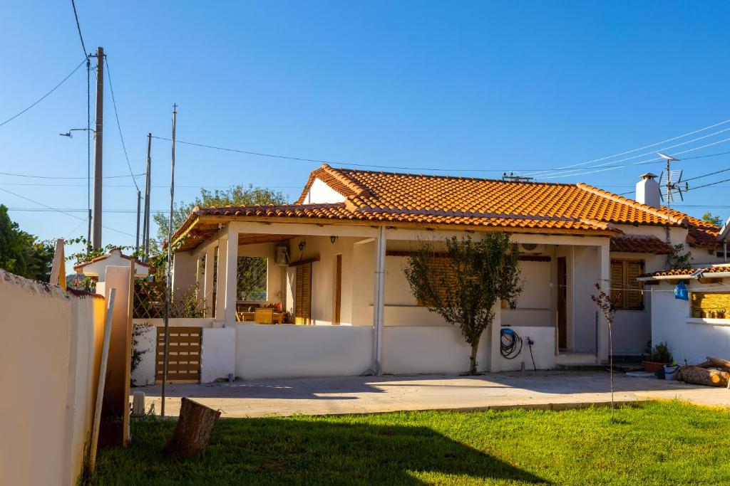 mały biały dom z ogrodzeniem i ogródkiem w obiekcie Villa Artemis Leto w mieście Artemida