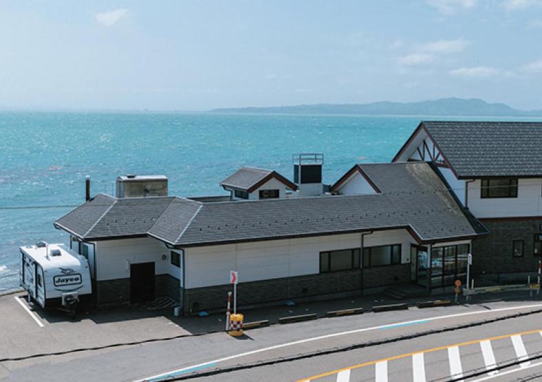 een huis met een busje geparkeerd voor de oceaan bij La se ri Resort and Stay in Himi