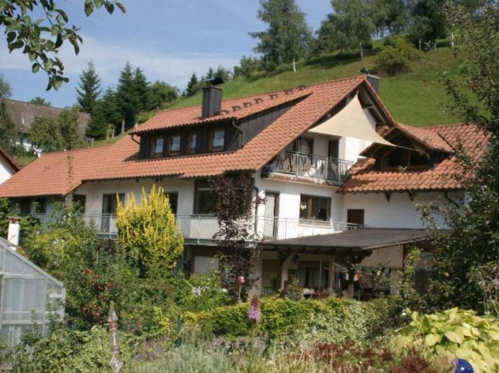 une grande maison blanche avec un toit rouge dans l'établissement Ferienwohnungen Golla-lang, à Oberharmersbach