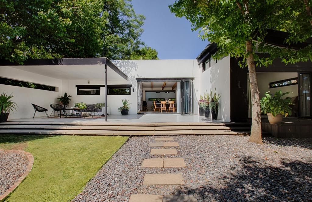 a white house with a patio and a yard at The Risa House in Muldersdrift