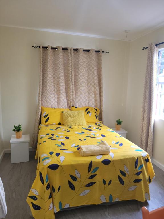 a bedroom with a yellow bed with a yellow comforter at Kensington Oval- 2 bed 1 Bath in Bridgetown
