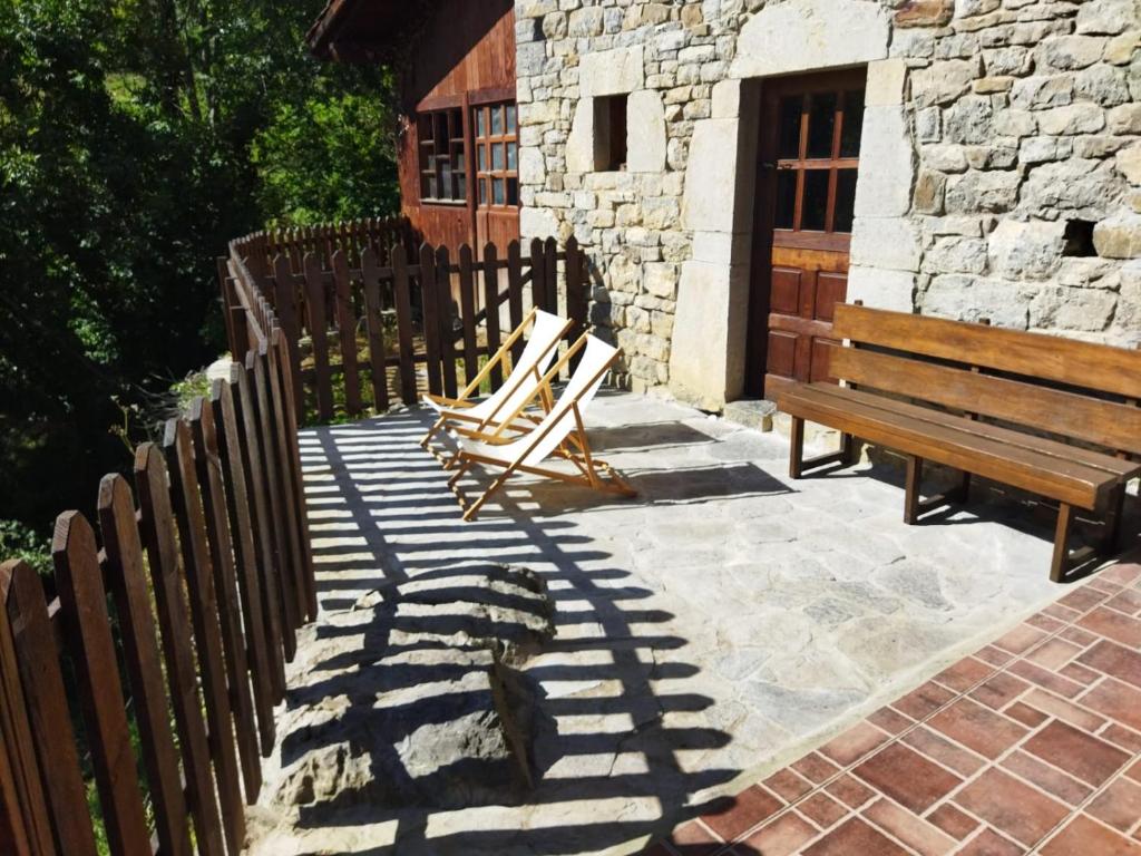 Tene的住宿－La Fontina de Tene，两把木凳坐在大楼旁边的庭院