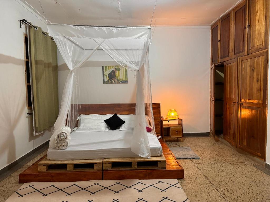 1 dormitorio con 1 cama con dosel en Karibu Africa Home, en Moshi