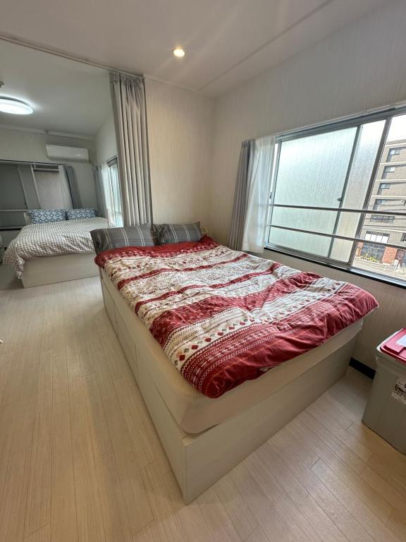 Un dormitorio con una cama grande y una ventana en 駅1分空港Airport近い, en Tokio