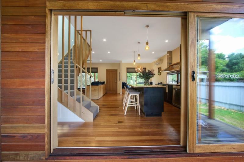 une cuisine et une salle à manger avec une porte coulissante en verre dans l'établissement The Wooden House, à Bright