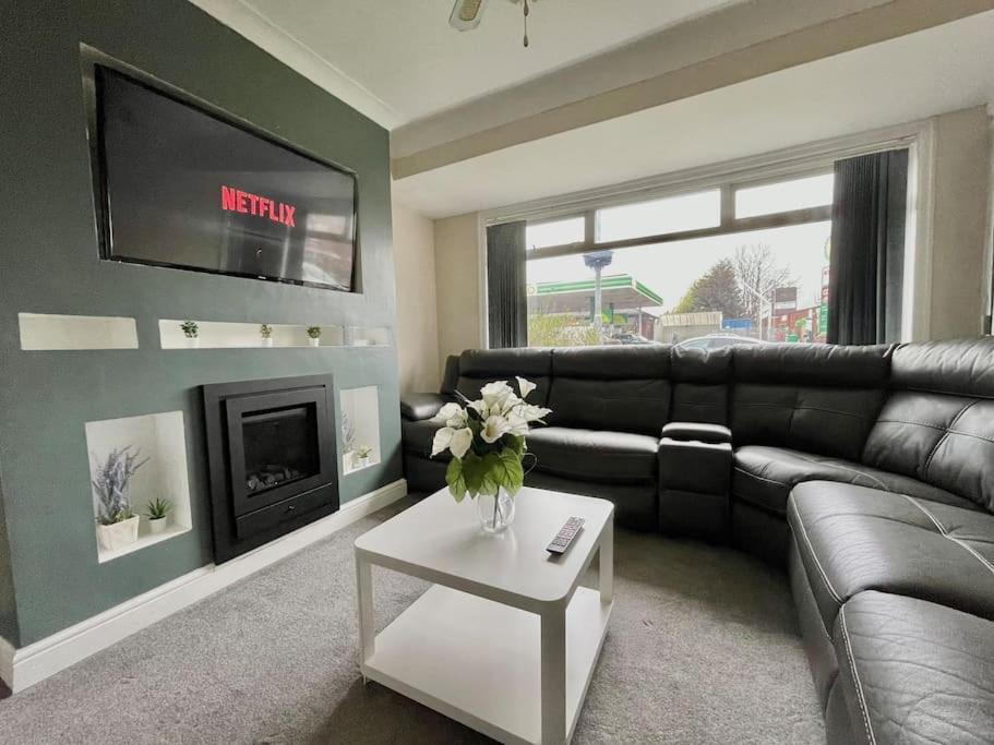 a living room with a couch and a fire place at (S12) Bright 3 Bed Home With Free Parking Leeds in Killingbeck