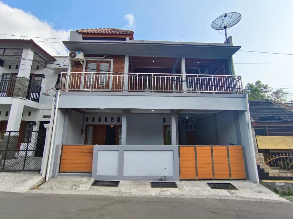 a house with a balcony on top of it at Omah Nogotirto Homestay Jogja in Ngingas
