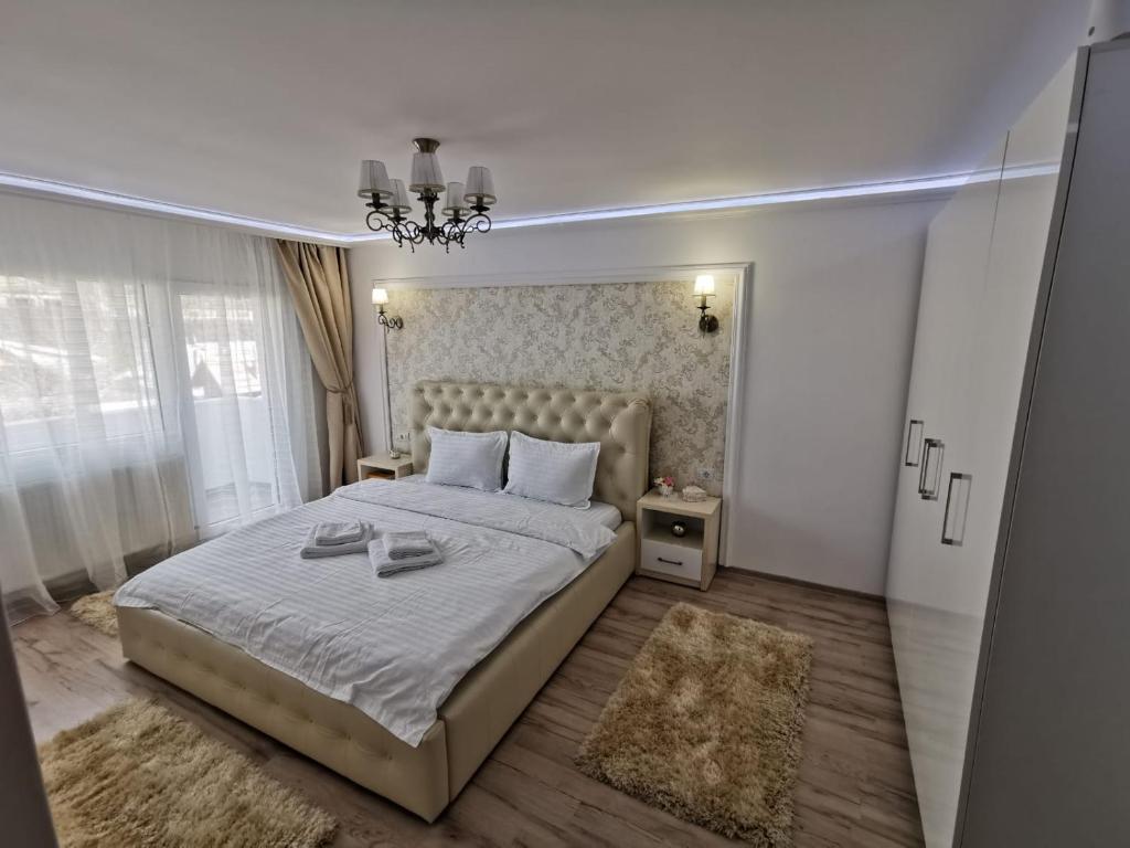 トゥルグ・オクナにあるApartament Gold Luxuryの大きなベッドとシャンデリアのある寝室