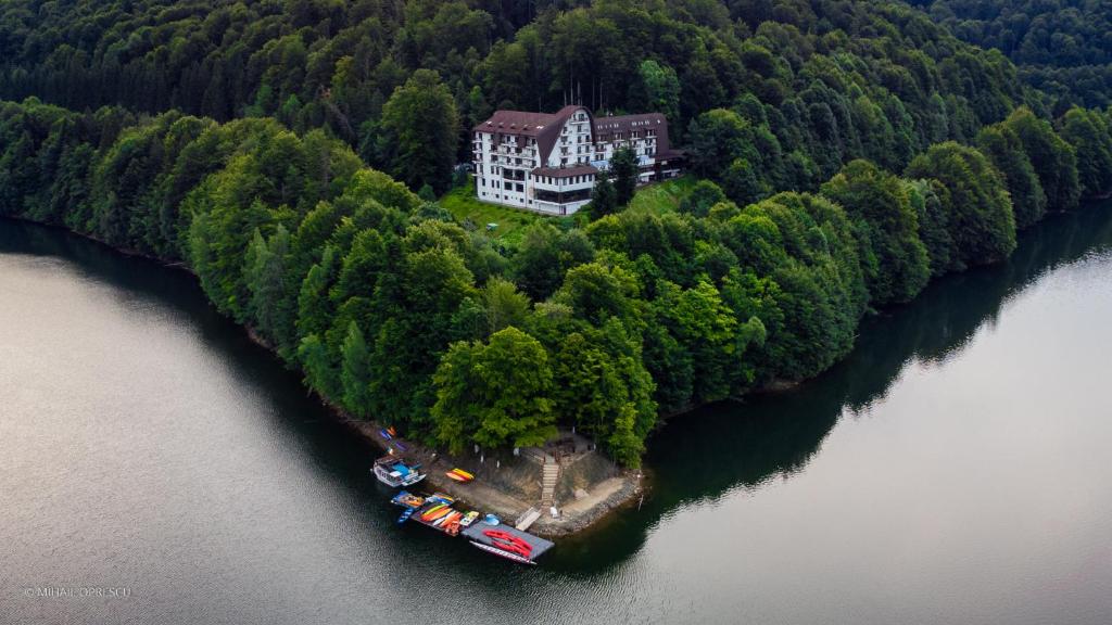 Căpăţîneni-Ungureni的住宿－魚谷酒店，水面上岛上房屋的空中景观
