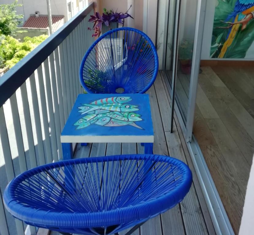 une table bleue et deux chaises sur un balcon dans l'établissement '' Sète à Vous'', à Sète