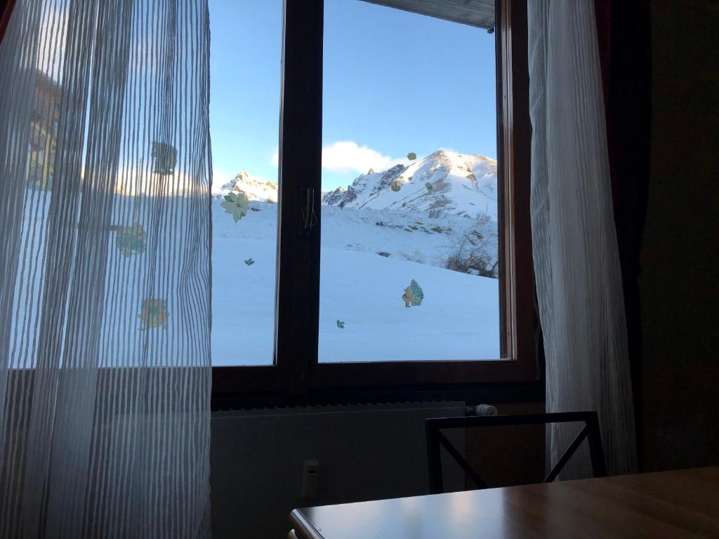 a window with a view of a snow covered mountain at orizzonte neve in Passo del Tonale