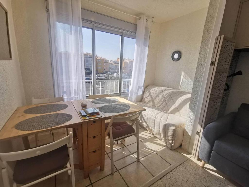 Apartamento pequeño con mesa y habitación con ventana en 028 Cap City B25, en Cap d'Agde