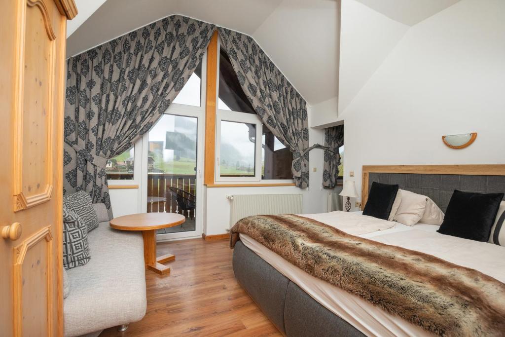 ein Schlafzimmer mit einem großen Bett und einem Fenster in der Unterkunft Appartements Alpengarten in Mallnitz