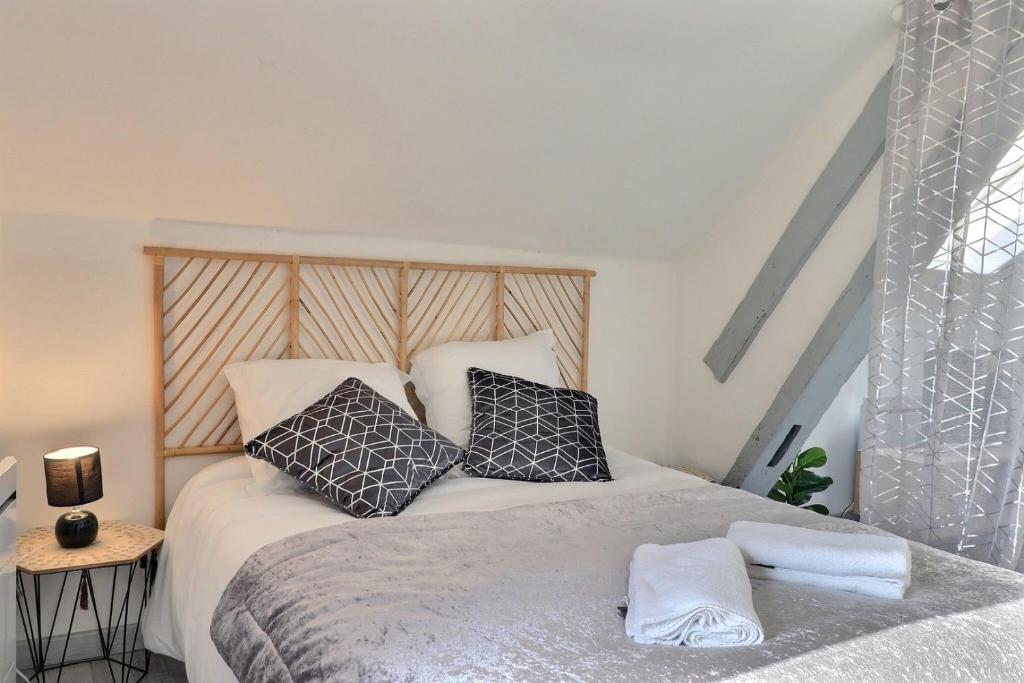een slaapkamer met een bed met zwart-witte kussens bij Nuance de gris ~ Hyper centre ~ Mon Groom in Troyes