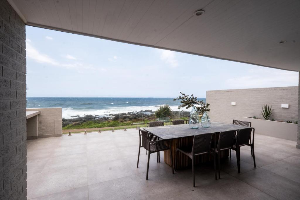 a dining room with a table and a view of the ocean at The Blonde Bungalow Ballito in Ballito