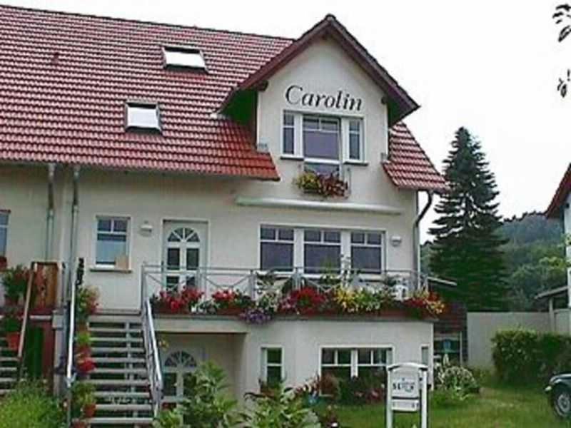 una gran casa blanca con un letrero que lee Caroline en Haus Carolin en Ahlbeck
