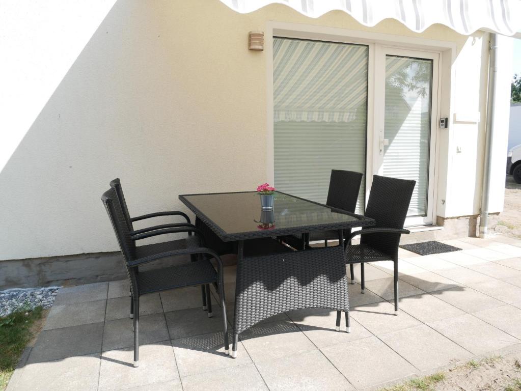 ツィノヴィッツにあるFerienwohnung zur Ostsee 1のダイニングテーブルと椅子付きのパティオ