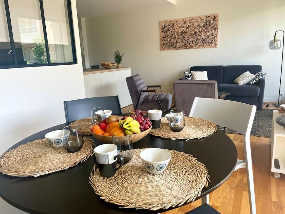 une table de salle à manger avec un bol de fruits dessus dans l'établissement Un nid dans les pins La Baule, à La Baule