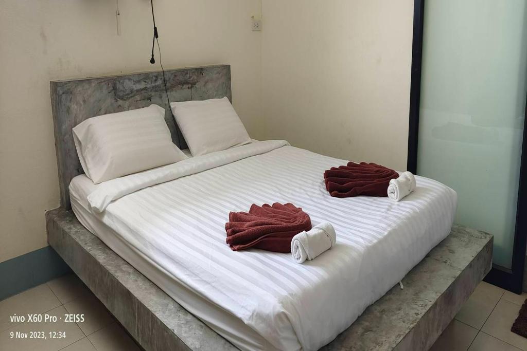 ein großes weißes Bett mit zwei Handtüchern darauf in der Unterkunft Top Harvest Rental in Baan Tai