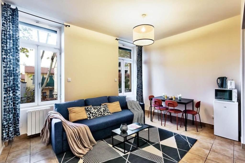 a living room with a blue couch and a table at APPARTEMENT ENTIER PROCHE DE LYON hypercentre in Saint-Fons