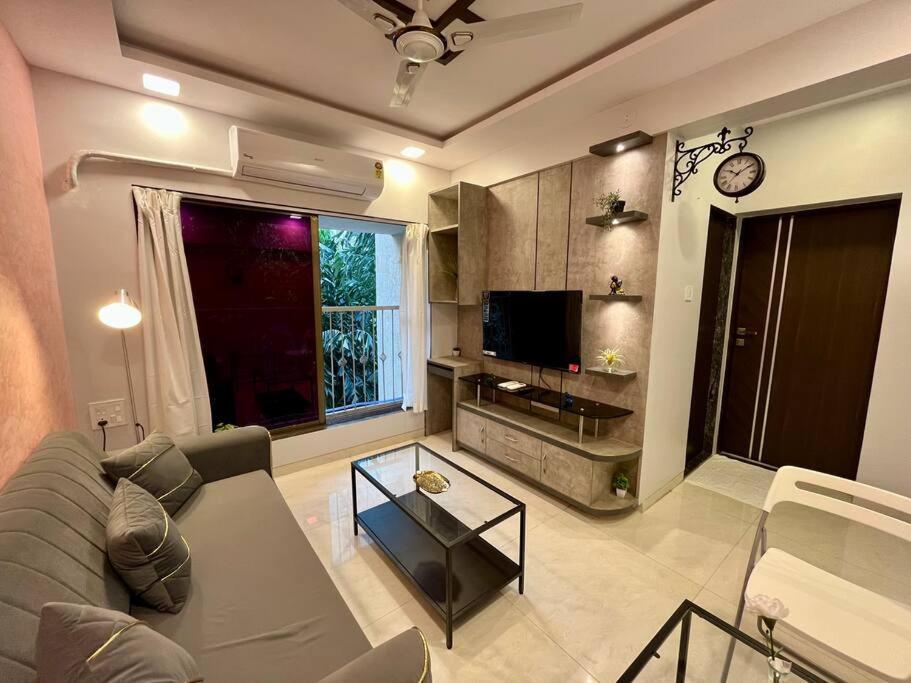 a living room with a couch and a tv at La Alba 1 BHK Serviced Apartment in Mumbai