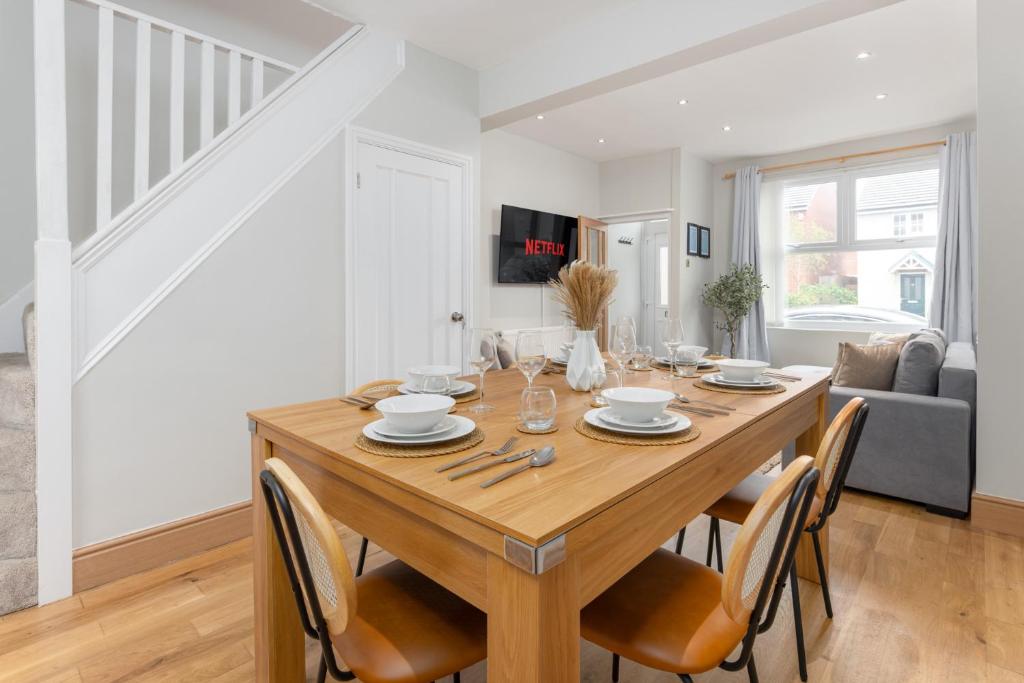 a dining room with a wooden table and chairs at Flatzy - Stunning Home by Lark Lane with Pool Table in Liverpool