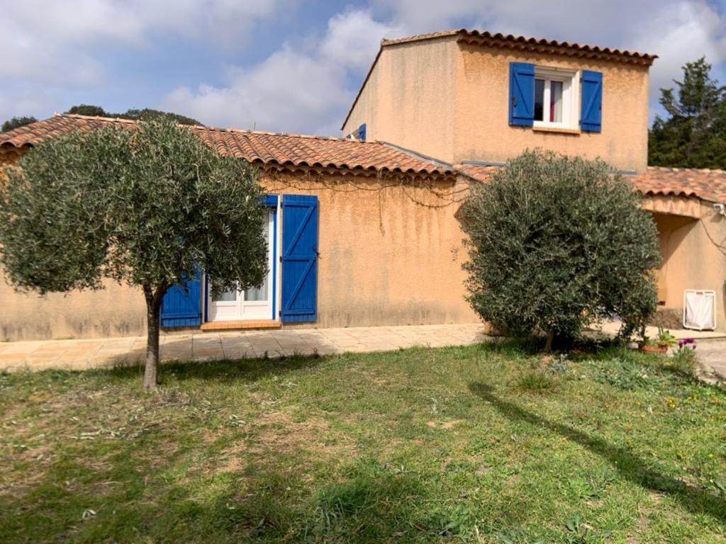 een huis met blauwe deuren en een boom ervoor bij Villa Provencale au bord de mer in Martigues