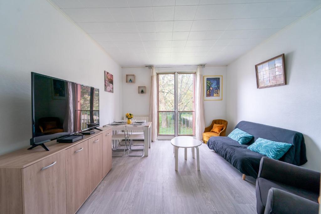 een woonkamer met een bank en een flatscreen-tv bij Florévasion - Appt pour 5 in Bobigny