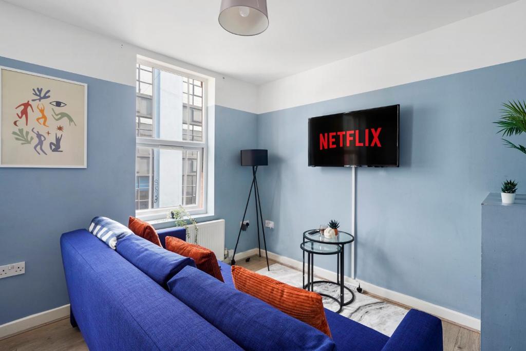 a living room with a blue couch and a tv at Beautiful Boutique Apartments in Central Bristol in Bristol