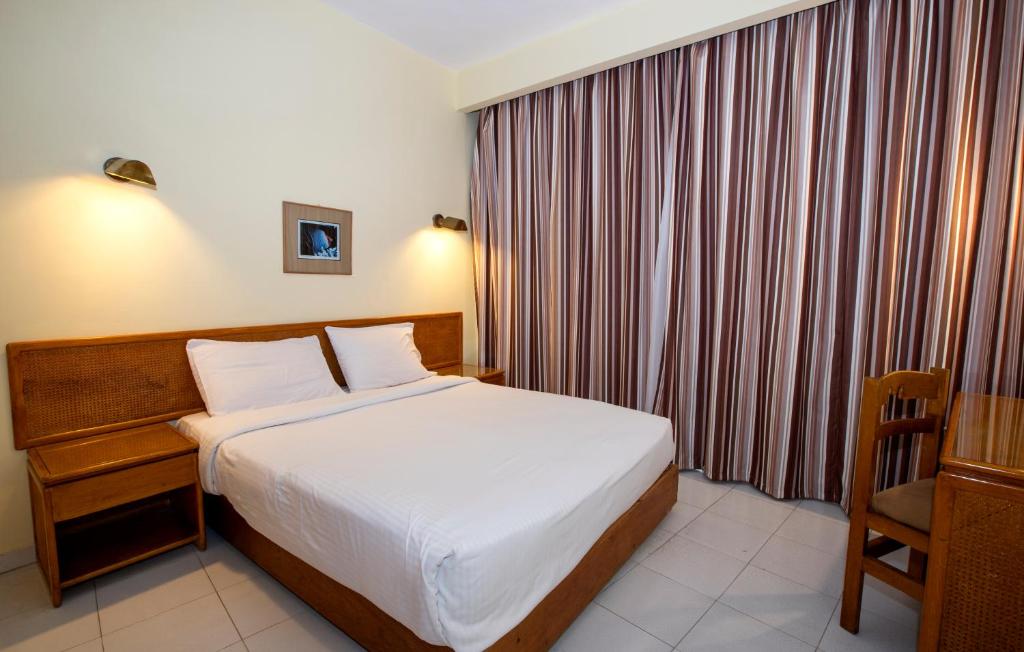 Habitación de hotel con cama y silla en Sunny Days Mirette Family Resort, en Hurghada