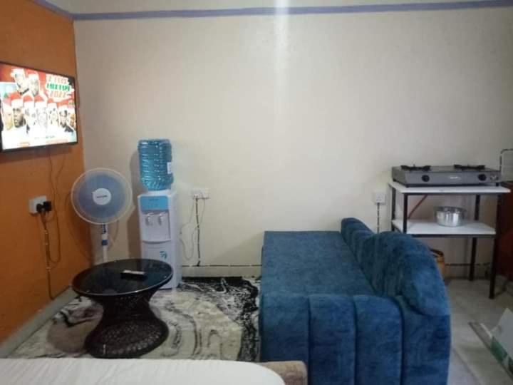 a living room with a blue couch and a table at Atiram furnished apartments in Nakuru