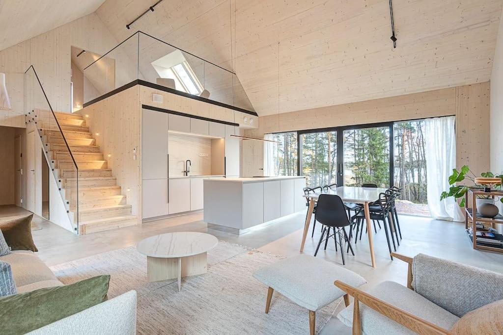a living room with a staircase and a table and chairs at Villa Pickala - Design - Seafront - Hot tub in Helsinki